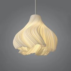 a white light hanging from a ceiling fixture in the shape of an object with wavy lines on it