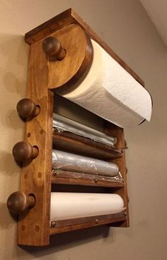 a wooden shelf with two rolls of toilet paper on it and some other items hanging from the wall