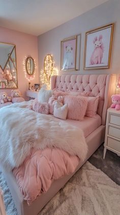 a pink and white bedroom with lots of pillows on the bed, rugs and lights