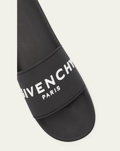 Givenchy slide sandals in rubber    Flat heel    Open toe    Single band vamp    Raised logo lettering    Molded footbed    Easy slide style    Made in Italy Designer Black Sandals With Logo Strap, Black Sandals With Logo Strap For Summer, Designer Beach Slides With Cushioned Footbed, Logo Slip-on Sandals For Summer, Designer Slides With Branded Insole For Beach, Logo Open Toe Sandals For Summer, Modern Sandals With Logo For Summer, Designer Beach Slides With Branded Insole, Modern Logo Sandals For Summer