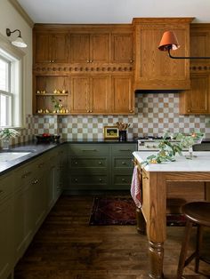 a kitchen with green cabinets and white counter tops