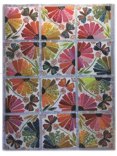 a quilted wall hanging with colorful flowers and butterflies