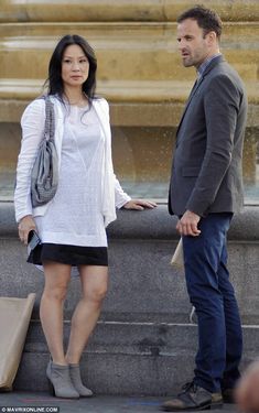 a man standing next to a woman near a fountain