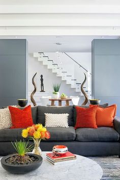 a living room filled with furniture and a spiral staircase leading up to the second floor