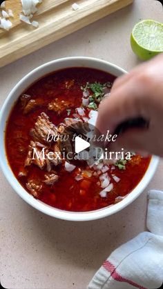 a bowl of soup with meat, onions and cilantro in it next to a cutting board