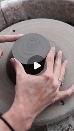 a person is making a vase out of clay with their hands on the pottery wheel