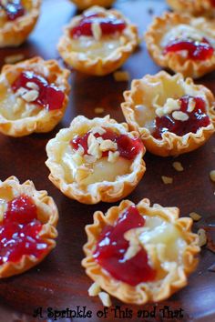 small pastries with jelly and nuts on a wooden platter, ready to be eaten