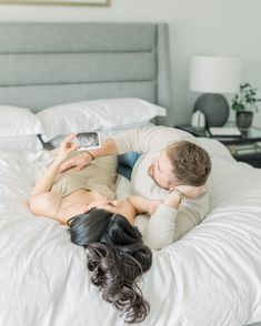 a man and woman laying on top of a bed