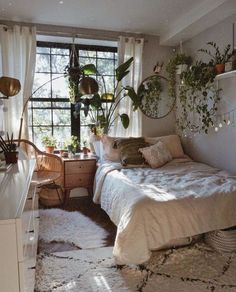 a bed room with a neatly made bed and lots of plants