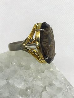 Beautiful large Smokey quartz cocktail ring. It features a gorgeous striking stone with a nicely detailed band. I'd estimate the age to be from the 1960's. Might be vermeil gold over silver as ring has some fading with gold. Ring does not have silver stamp. Size estimated to be an 8.5 to 9 woman's ring finger. Gold Gemstone Rings For Evening, Classic Rings With Prong Setting For Evening, Classic Evening Rings With Prong Setting, Emerald Cut Gemstone Rings For Evening, Vintage Emerald Cut Gemstone Rings, Classic Open Crystal Ring For Formal Occasions, Elegant Formal Topaz Ring With 17 Jewels, Classic Formal Crystal Open Ring, Heirloom Round Evening Ring