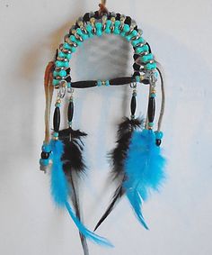 a native american style dream catcher with feathers and beads on it's headdress