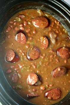 a crock pot filled with beans and sausage