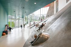 children are playing on the slide in an indoor skate park