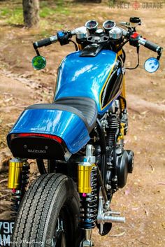 a blue motorcycle parked on top of a dirt road