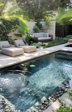 an outdoor pool surrounded by plants and rocks