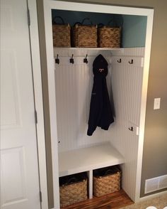 a coat rack with baskets and coats hanging from it's hooks, next to a door