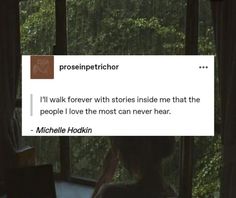 a woman sitting at a desk in front of a window with the caption'i'll walk forever with stories inside me that the people i love the most can never hear '