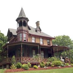 a large house with a tower on the top of it's roof and balcony