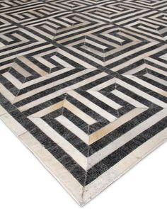 a black and white area rug with an intricate design on the top, in front of a white background