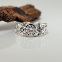 a close up of a ring on a white surface with a piece of wood in the background