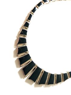 Elegant, high fashion mid century modern Taxco Mexico, Mexican 950 sterling silver and onyx hinged necklace.  Classic, beautifully crafted and engineered to sit beautifully on the neck and makes it very comfortable to wear with tongue box clasp.   It is signed TM Mexico 950 in two different places.  Very high quality and bears some similarity to a Pineda piece - the engineering is the same.  It has descending links from approx. 3/4 inches to clasp.   CONDITION:  Excelling pre-owned vintage condition w/ a good working clasp.   SIZE APPROX:  16 1/2 inches, weighs approx. 60 grams and 3/4 at widest BUYER RESPONSIBILITIES: While I do my best to describe any potential flaws with equal attention to its attributes, please use the zoom feature to examine the item to make a determination if this me Formal Silver Onyx Necklaces, Modern Polished Jewelry For Evening, Modern Evening Jewelry With Polished Finish, Modern Black Necklace For Evening, Modern Metal Necklaces For Formal Occasions, Silver Necklace With Polished Finish For Evening, Modern Black Enamel Jewelry, Retro Black Necklaces For Party, Formal Onyx Necklace With Black Enamel