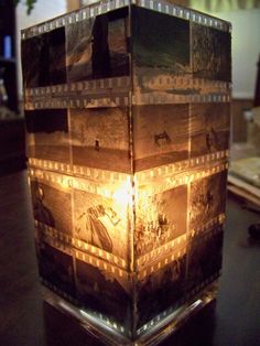 a light that is sitting on top of a table next to a vase with pictures on it