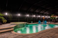 an indoor swimming pool surrounded by patio furniture