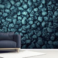 a couch sitting in front of a wall with skulls on it's back side