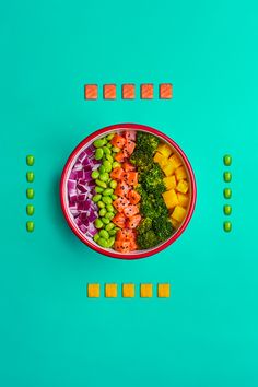 a bowl filled with lots of different types of food on top of a blue surface