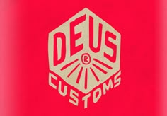 a red and white sticker with the words deus customs on it's side