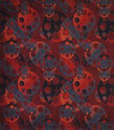 a red, black and blue pattern with skulls in the center on a red background