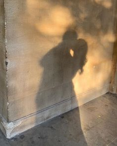 the shadow of a person standing next to a wall