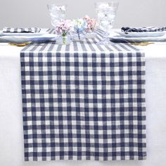 a blue and white checkered table cloth with flowers on it