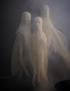 three ghostly people standing in the fog