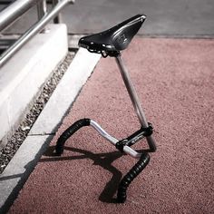 a bicycle parked on the side of a road next to a metal rail and railing