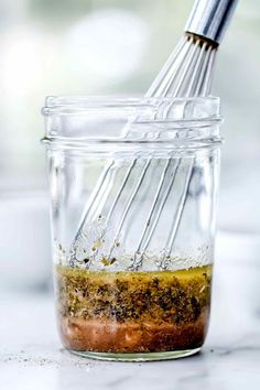 a whisk is being used to mix ingredients in a jar