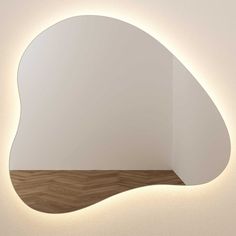 a white wall mounted light with a wooden floor in front of it and an oval shaped mirror on the wall