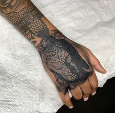 a person's hand with a tattoo on it that has an owl in the center