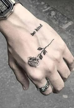 a person's left hand with a tattoo on it and the words be kind