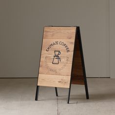 a wooden sign sitting on top of a white floor next to a black metal frame