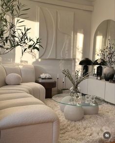 a living room filled with furniture and a large mirror on top of the wall next to a white couch