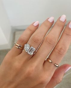 a woman's hand with three different rings on her fingers and one has a diamond ring