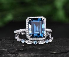 a blue and white diamond ring on top of a piece of wood