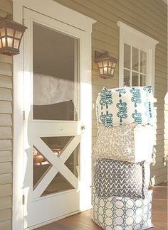 a stack of pillows sitting on top of a wooden floor in front of a door