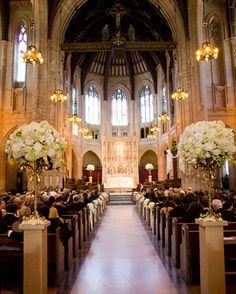 a church filled with lots of pews covered in white flowers and centerpieces