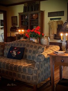 a living room filled with furniture next to a table and two candles on top of it