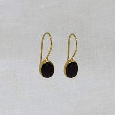 Black Onyx and 18k Gold Vermeil Oval Drop Earrings Natural cabochon black onyx gemstones in a simple 18k gold plated silver setting, with a hook fitting. Simple drop earrings perfect for everyday wear.  Dimensions (approx): * Length: 2.2cm including hook * Turquoise: 7mm x 9mm Materials: * 18k Gold Plated Silver * Black Onyx Beyond Biasa creates unique jewellery that is inspired by antique and tribal designs from around the globe. All of our pieces are handmade so please allow for slight variati Formal Onyx Gemstone Earrings, Elegant Black Oval Earrings, Classic Oval Earrings With Ear Wire, Black Onyx Earrings With Polished Finish, Polished Onyx Earrings For Gift, Black Oval Earrings For Formal Occasions, Classic Onyx Earrings Gift, Classic Black Earrings With Polished Finish, Elegant Black Cabochon Earrings