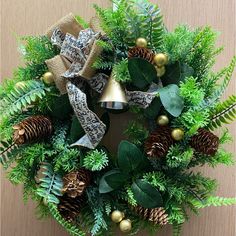 a christmas wreath with pine cones, evergreens and bells hanging from the front door