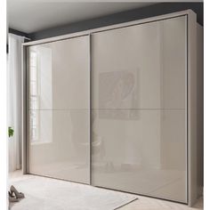 a white closet with sliding doors in a room