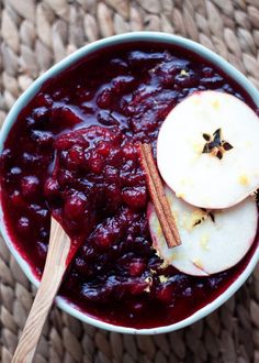 an apple and cranberry sauce in a bowl with cinnamon sticks on top, ready to be eaten